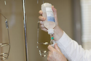 Detailaufnahme Infusionsflasche in die eine Nadel gesteckt wird